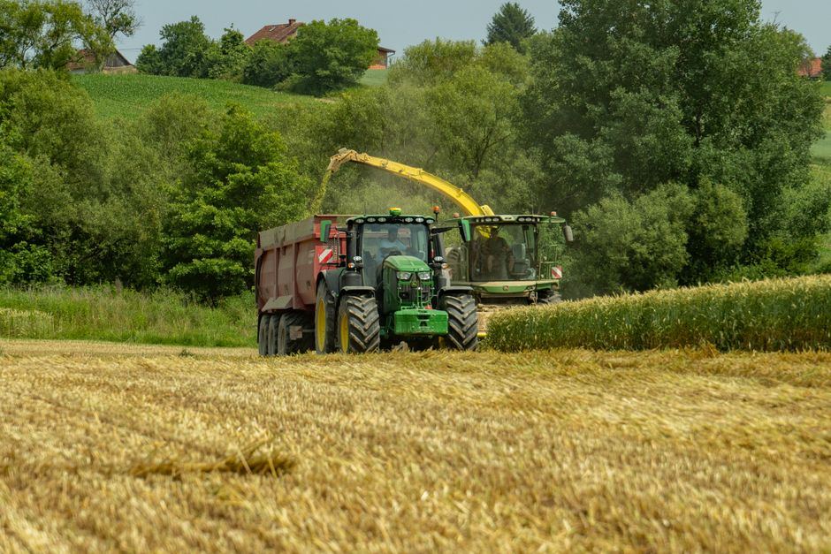 Combină și tractor la seceriș într-un lan de grâu european