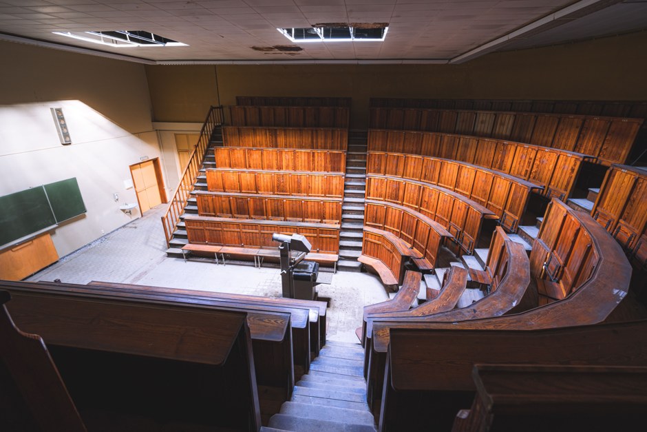 Amfiteatru universitar clasic, cu bănci de lemn și tablă