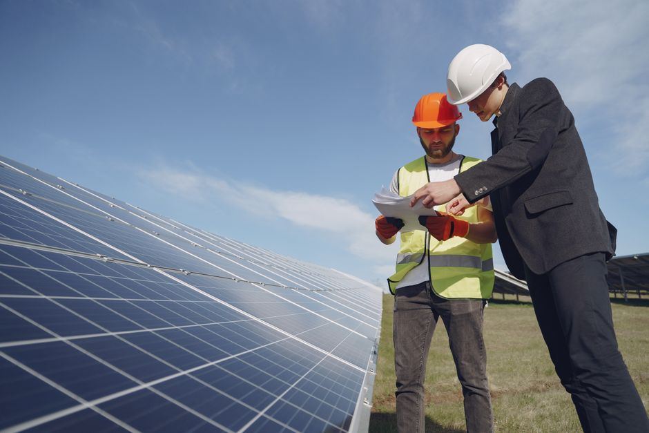 Inginer verificând documentație lângă panouri solare