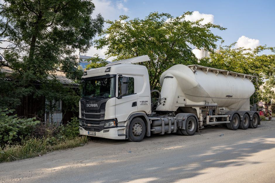 Autotractor european cu cisternă, parcat pe o stradă cu copaci